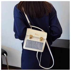 Detail view of cream-white PU crossbody bag with gold clasps and mesh texture panel
