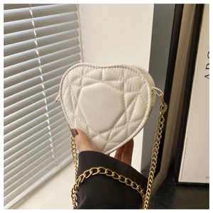 Detail shot of white heart-shaped bag with quilted pattern and gold chain strap