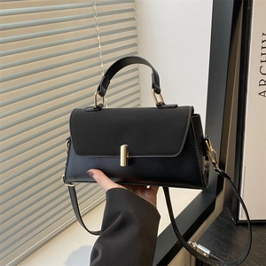 Minimalist black faux leather shoulder bag with gold twist lock and top handle