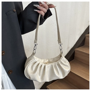 Gros plan détaillé sur la texture plissée et le crochet en métal du sac nuage crème