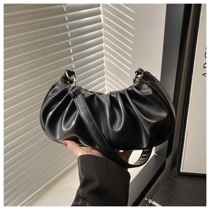 Detailed view of black pleated cloud bag with soft leather texture and silver hardware