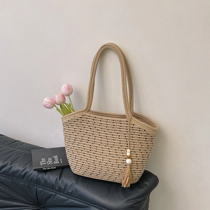 Borsa tote in cotone intrecciato beige con motivi neri e nappine decorative in legno