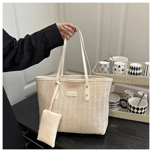 Détail d'un sac cabas tissé crème avec texture en V et mini pochette assortie incluse