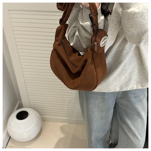 Detail of dark brown corduroy crescent bag with matching round coin purse on strap