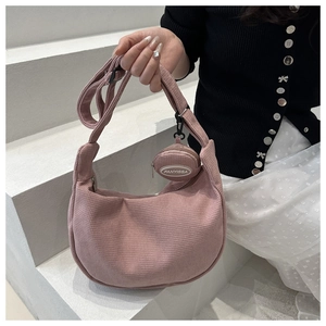 Detail of pink corduroy crescent bag with adjustable wide strap and mini coin purse