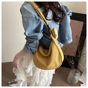 Detailed view of yellow corduroy half-moon crossbody bag with a mini matching coin purse