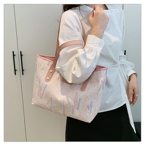 Détail du sac cabas rose avec gaufrage floral et broderie colorée sur la bandoulière