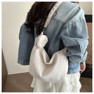 Detail of cream corduroy hobo bag with adjustable strap and small round pendant coin purse