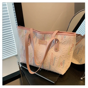 Détail du sac cabas rose avec tissu jacquard géométrique et broderie ondulée arc-en-ciel