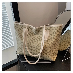 Detailed close-up of a large capacity tote bag with brown letter M monogram print