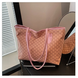 Detail of printed tote bag with M-pattern and premium pink leather trim in soft light