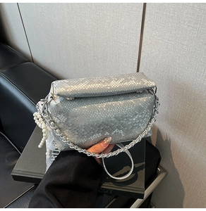 Detail of silver snake texture box bag with metal chain and pearl lace charm
