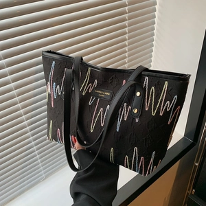 Large black tote bag with colorful embroidery and double leather handles for daily use