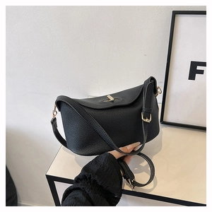 Detailaufnahme der schwarzen Lederhandtasche mit goldener Metall-Drehverschluss