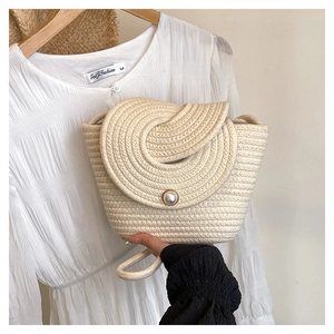 Détail du sac seau tissé avec rabat en spirale et fermeture à bouton perle