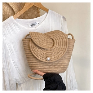 Vue détaillée du sac seau en paille tissée à la main avec perle et bandoulière en coton