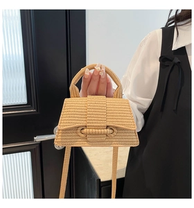 Detail of hand-woven hourglass crossbody bag featuring a curved base and structured handle
