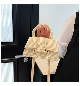 Detailed macro shot of a beige straw woven mini handbag with natural texture