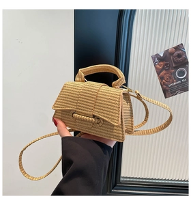 Mini khaki straw handbag featuring detailed woven texture and a rounded top handle