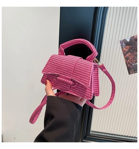 Detail of rose pink woven mini handbag with textured finish and braided handle strap
