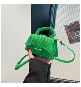 Detail of bright green woven mini bag featuring fine texture and crossbody strap