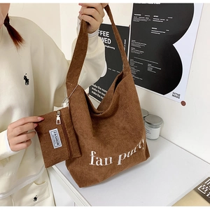 Detail eines braunen Cord-Hobo-Tote-Bag-Sets mit gestickten Buchstaben und Beutel