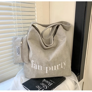 Detail der hellgrauen Cord-Tasche mit fan purty Stickerei und passender Mini-Tasche