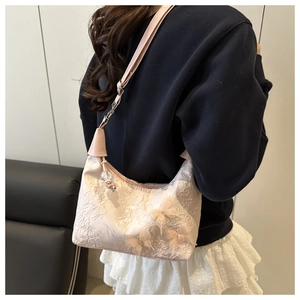 Détail d'un sac sous le bras en dentelle rose avec broderies papillons 3D délicates
