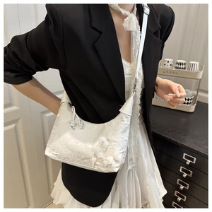 Detailed shot of white lace bucket bag with 3D butterfly embroidery and sphere charm