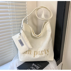 Detail der cremeweißen Cord-Shopper-Tasche mit goldener Bestickung und Textur