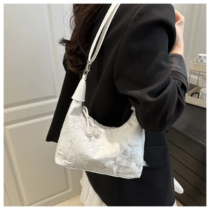 Detail of white lace hobo bag with 3D floral textures and elegant shoulder strap