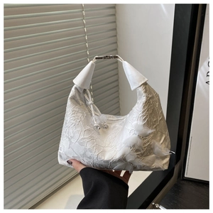 Détail d'un sac à main en dentelle blanche avec papillons 3D en organza et anse en cuir