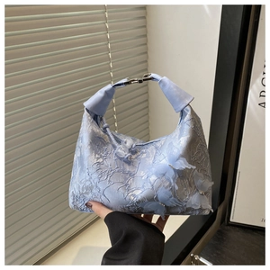 Détails de broderie sur sac en dentelle bleu clair avec papillons 3D et perles fines