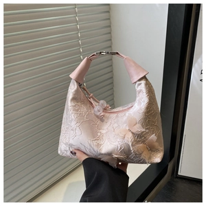 Détail du sac hobo en dentelle rose avec papillons 3D et breloque en perles