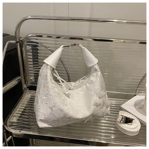 Close-up of elegant white bucket bag featuring floral embroidery and 3D chiffon petals