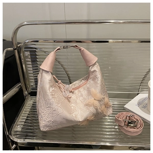 Detail of pink lace bucket bag with 3D butterfly accents and textured handle