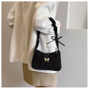 Détail du sac à bandoulière plissé noir avec papillon argenté et bandoulière à nœud