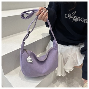 Détail du sac hobo violet à texture gaufrée avec un joli pendentif de chiot