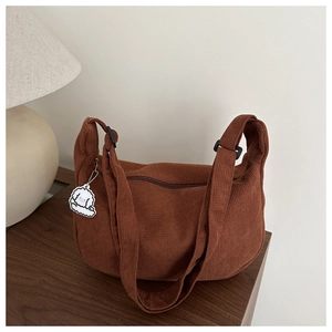 Detail of dark brown corduroy tote bag with waffle texture and cute dog pendant