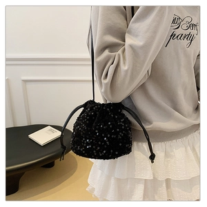 Detail shot of the black sequined bucket bag with drawstring closure and fine texture