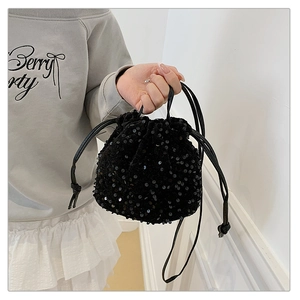 Detailed view of a black sequined drawstring bag with reflective round sequins texture