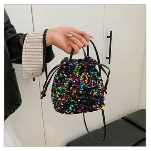 Detail of glitter sequins on black bucket bag with drawstring and leather strap