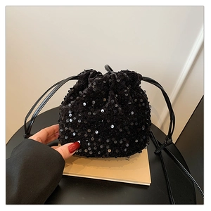 Détail d'un sac à paillettes noires montrant la texture réfléchissante et le cordon