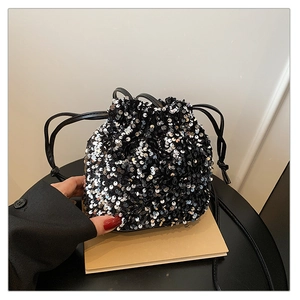 Détail d'un sac seau noir à paillettes argentées avec fermeture à cordon serré