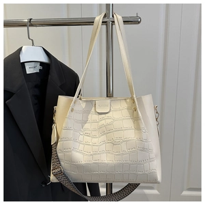 Close-up of cream white crocodile embossed tote bag with woven wide shoulder strap