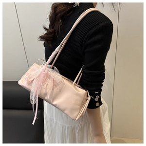 Nahaufnahme der rosa baguette tasche mit eleganter spitzen schleife und dünnen riemen
