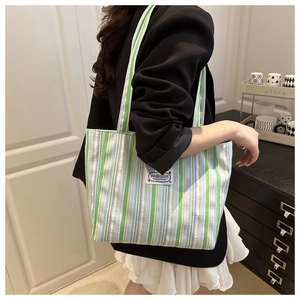 Detail showing the textured canvas fabric and colorful striped pattern of the tote bag