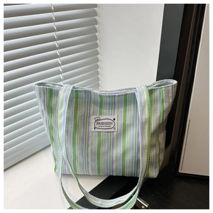 Detailed macro view of green and purple striped canvas tote with woven pleated texture