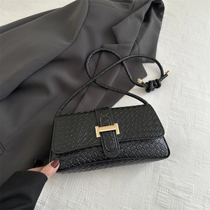 Bolso de mano negro minimalista con patrón de cocodrilo y hebilla metálica dorada