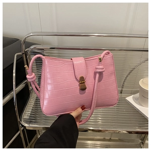 Detail of pink croc-embossed leather underarm bag with vintage gold metal clasp